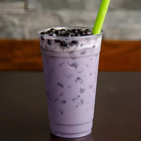 A Teabreak Pho & Boba taro boba drink with black tapioca pearls and a green straw.